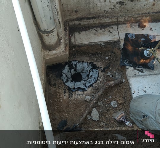 חומר איטום שחור סביב צינור על רצפה